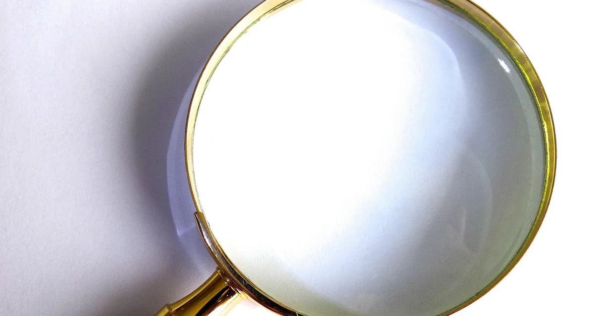Lupa de aro dourado sobre fundo claro, ilustrando como limpar o histórico do Google